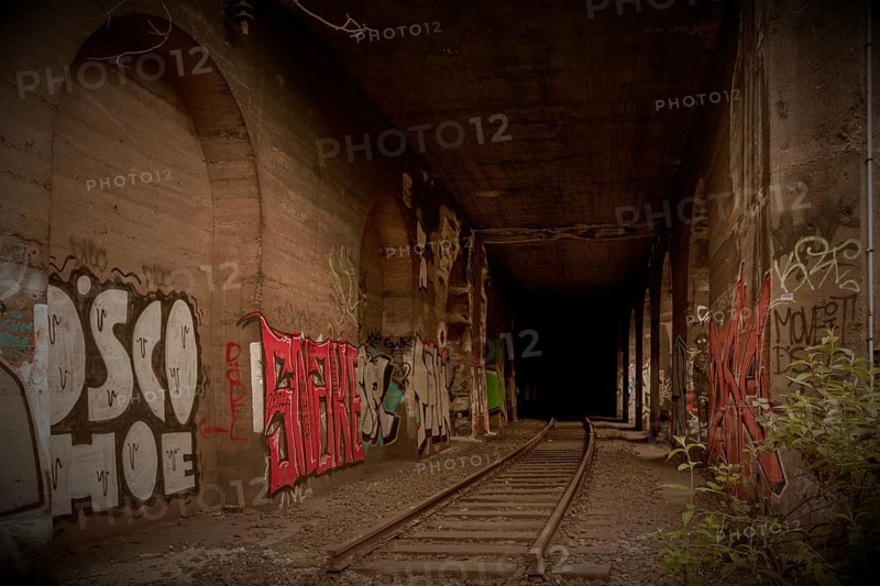 Abandoned tunnel with tracks and colourful graffiti on the walls, former Rethel railway branch, Lost Place, Flingern, Duesseldorf, North Rhine-Westphalia, Germany, Europe