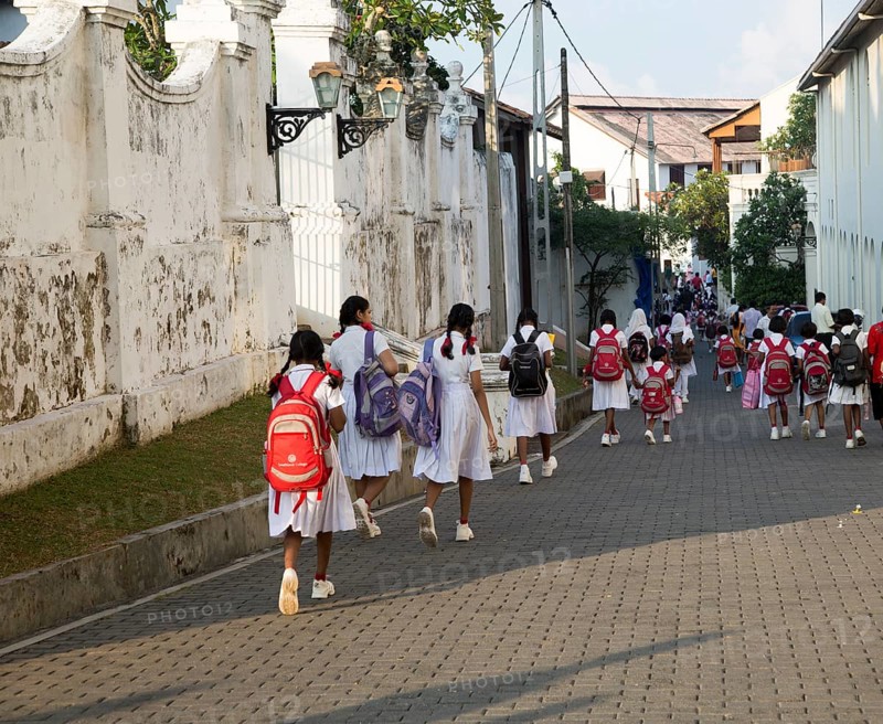 School girls in uniform walking in a street in the historic town of Galle, Sri Lanka, Asia