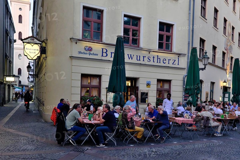 People sitting in the garden in front of the traditional restaurant Bratwurstherzl at Viktualienmarkt, Munich, Bavaria, Germany, Europe