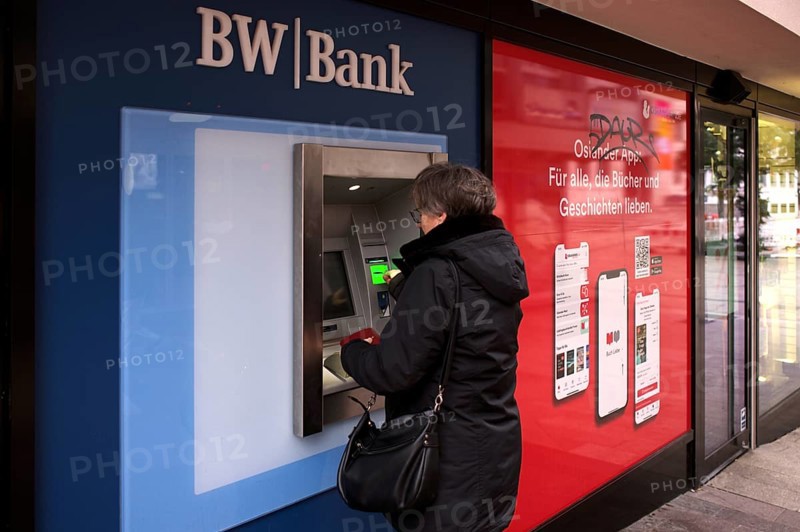Elderly woman, best ager, inserts EC card, credit card, PIN, purse, ATM of BW-Bank Baden-Wuerttembergische Bank, logo, Stuttgart, Baden-Wuerttemberg, Germany, Europe