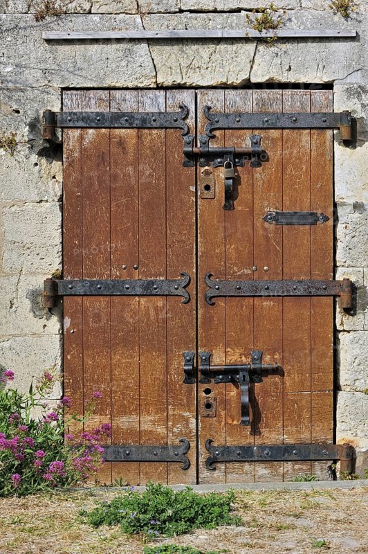 Old wooden door with heavy hinges in the citadel at Le Chateau-d'Oleron on the island Ile d'Oleron, Charente-Maritime, France, Europe