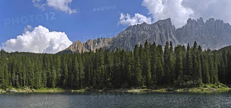 The lake Lago di Carezza, Karersee surrounded bij mountain peaks and pine forest in the Dolomites, Italy, Europe