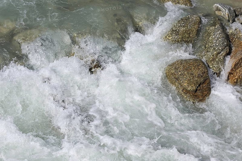 Glacial water flowing fast over boulders in alpine mountain stream, Swiss Alps, Switzerland, Europe