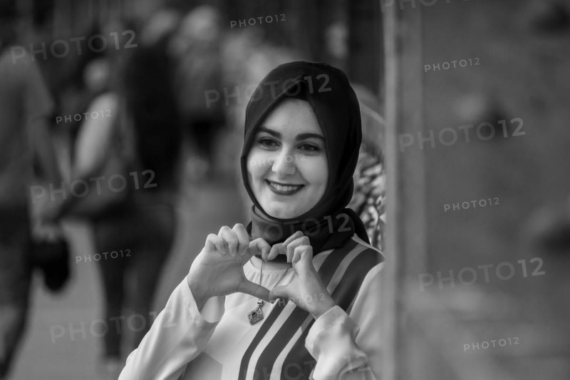 Friendly smiling woman in hijab making a heart sign with her hands, Hohenzollernbruecke, Cologne Deutz, North Rhine-Westphalia, Germany, Europe