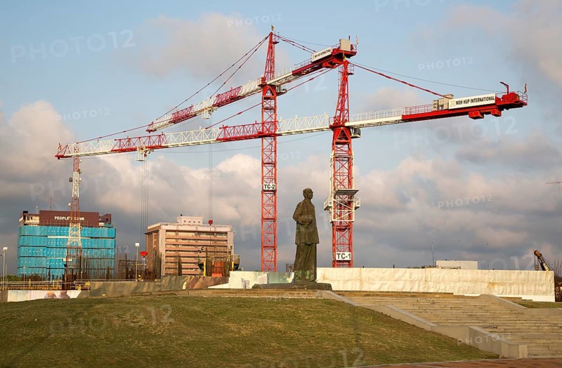 Cranes tower over statue of S.W.R.D. Bandaranaike at construction site in central Colombo, Sri Lanka, Asia
