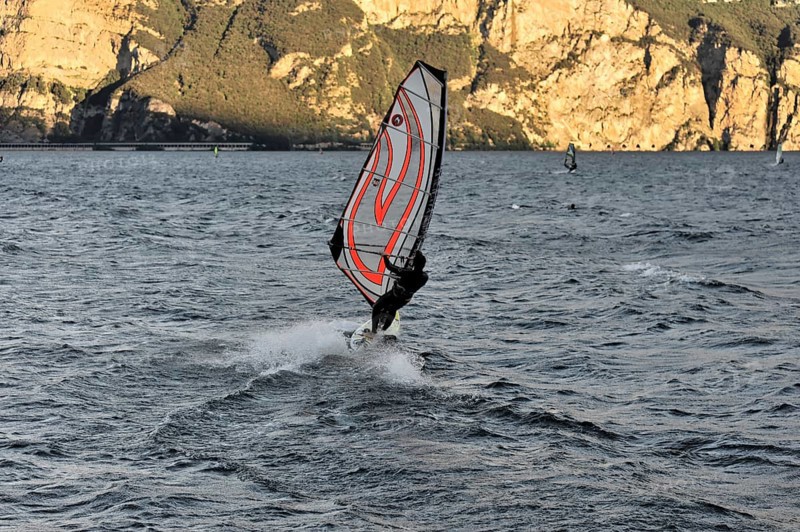 Windsurfers surfing in strong winds on Lake Garda near Malcesine, Veneto, Italy, Europe