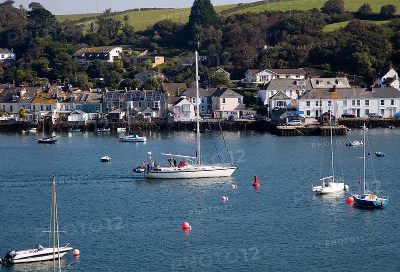 Yachts passing moorings on River Fal, Flushing, Cornwall, England, UK