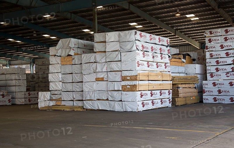 Piles of imported timber planks in Anglo Norden warehouse, Ipswich, Suffolk, England, UK