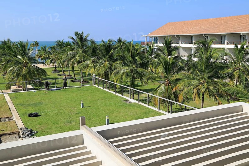 Amaya Beach Resort and Spa hotel, Pasikudah Bay, Eastern Province, Sri Lanka, Asia staff tending sedum grass roof garden, Asia
