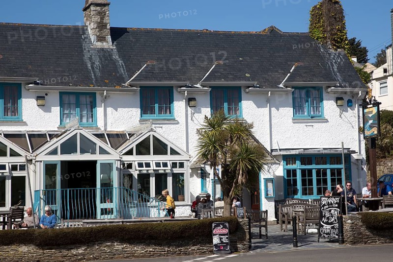 People sitting outside The Rising Sun pub, St Mawes, Cornwall, England, UK