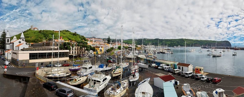 Wide angle shot of the harbour of Horta with boats, buildings and cars on the coastal road, Horta, Faial Island, Azores, Portugal, Europe