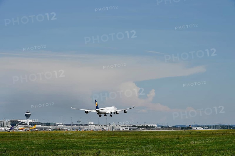 Lufthansa Airbus A340 landing on southern runway, with thundercloud and storm front in the background, terminal and tower, Munich Airport, Upper Bavaria, Bavaria, Germany, Europe