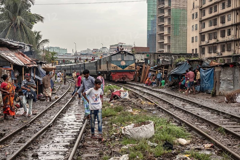 A train passes through an informal settlement built close to a railway line, Tejgaon Slum, Area, Dhaka, Bangladesh, Asia