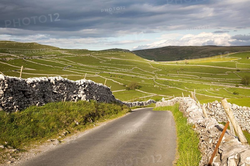 Country lane and dry stonewalls, Malham, Yorkshire Dales national park, England, UK