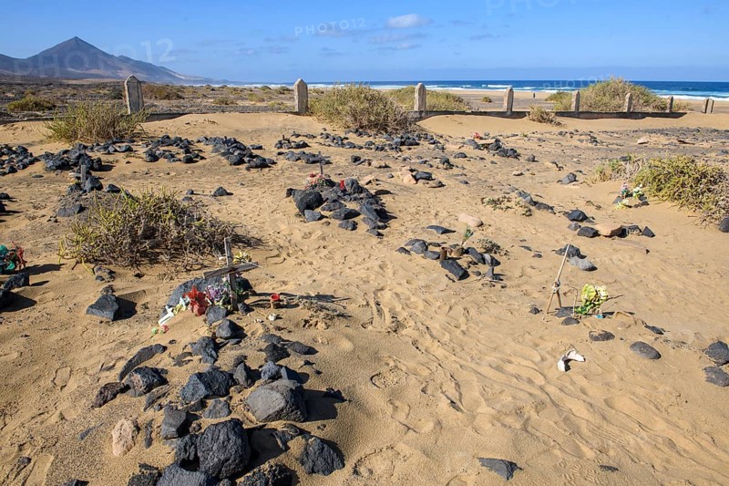 View of old sandy historical cemetery from 1950s with several graves marked by stones from abandoned village of Cofete on west coast of Jandia peninsula, in the background Atlantic Ocean, Cofete, Jandia, Fuerteventura, Canary Islands, Canary Islands, Spain, Europe