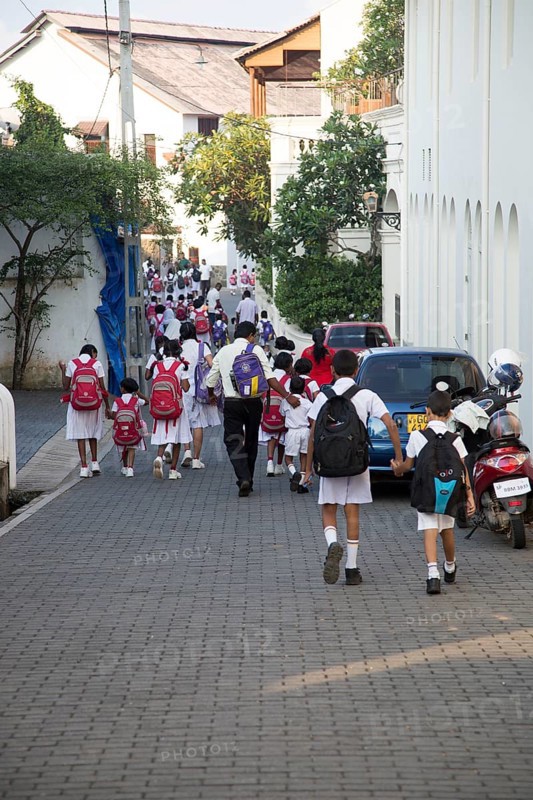 School girls in uniform walking in a street in the historic town of Galle, Sri Lanka, Asia