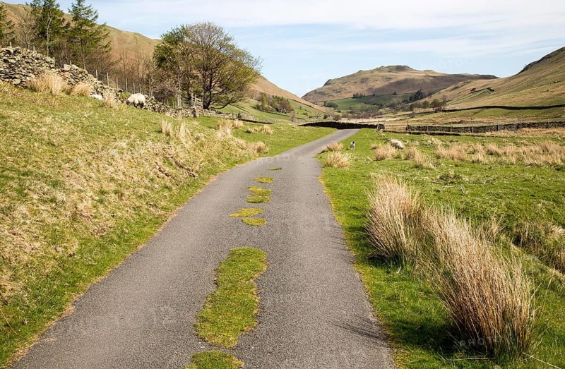 Narrow road and dry stonewall, Boredale valley, Martindale, Lake District national park, Cumbria, England, UK