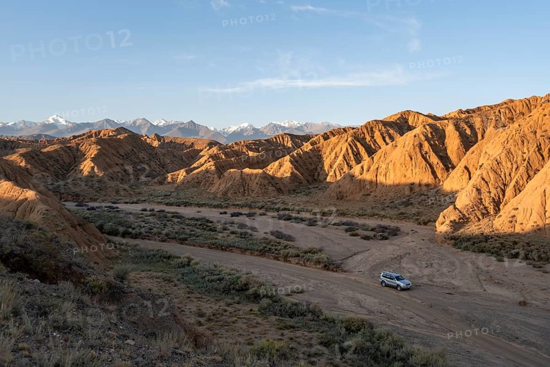 Off-road vehicle on off-road road, eroded hilly landscape, Badlands, Valley of the Forgotten Rivers, near Bokonbayevo, Yssykkoel, Kyrgyzstan, Asia