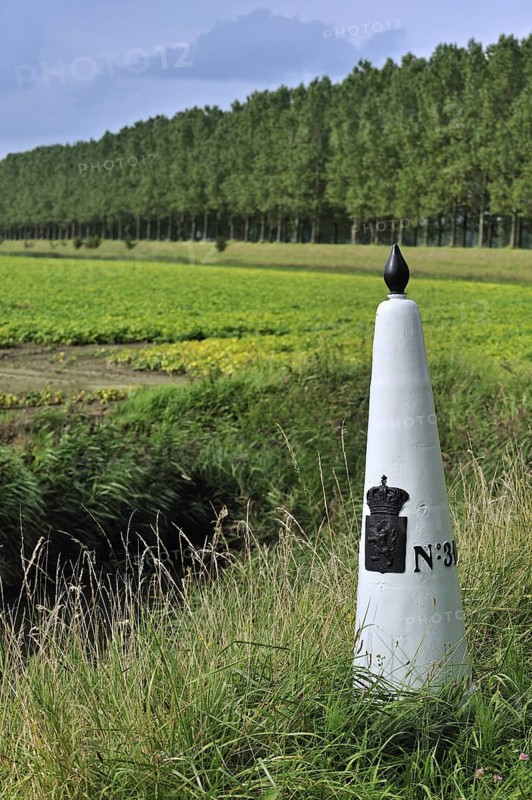 White boundary, border post between the Netherlands and Belgium in polder, Meetjesland
