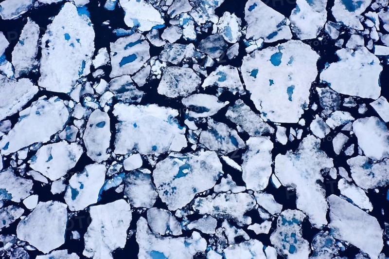 Aerial view over sea ice, drift ice, ice floes with melt ponds containing freshwater in the Arctic Ocean, Nordaustlandet, Svalbard, Spitsbergen
