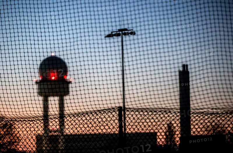 Evening mood at Tempelhofer Feld, view through a fence to the radar tower at the former Tempelhof Airport, Berlin, 15 December 2022