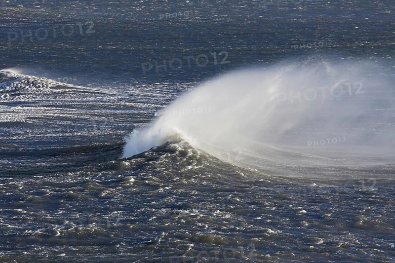 Wave crest at Arctic sea showing airborne spray and spindrift due to high winds