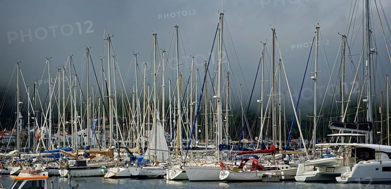 Sailboats in the sunny harbour of Horta with dark clouds above, Horta, Faial Island, Azores, Portugal, Europe