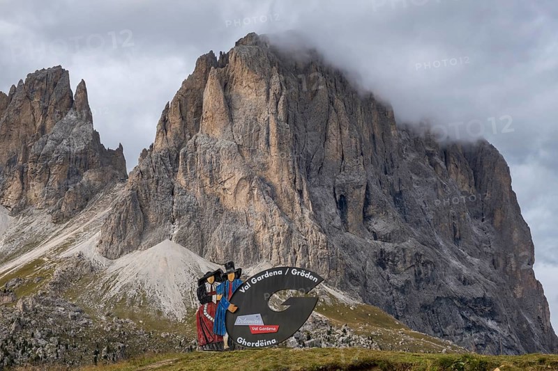 Traditional traditional costume couple advertising sign on the Sella Pass, behind Sassolungo, South Tyrol, Italy, Europe