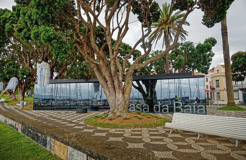 Modern glass building opposite historic houses in a green park, Horta, Faial Island, Azores, Portugal, Europe
