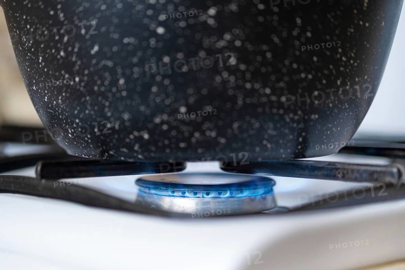 Closeup view of a pan on a gas hob, cooking on a gas stove