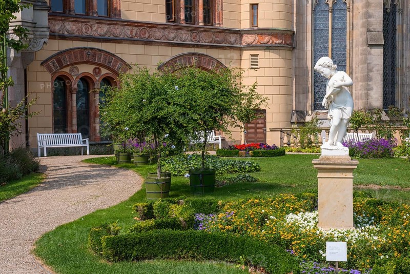Castle garden with white marble sculpture The Allegory of Water or Boy with Shell Horn by Christian F. Genschow, statue, figure, in the background Schwerin Castle, east facade and parts of the castle church, Schwerin, Mecklenburg-Vorpommern, Germany, Europe