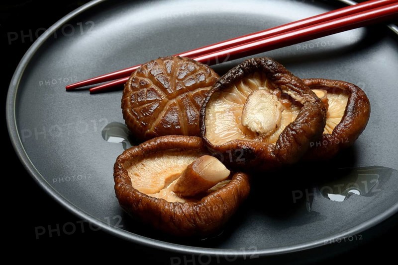 Dried and soaked shiitake mushrooms on a plate with chopsticks