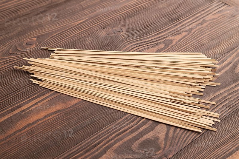 Japanese buckwheat soba noodles on brown wooden background. Side view, close up