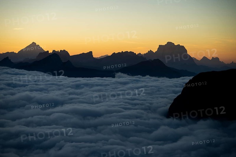 Sunrise over a sea of fog with the peaks of the Sella massif in the background, Corvara, Dolomites, Italy, Europe