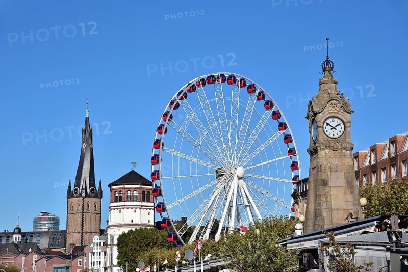 View over the Rhine terrace of Duesseldorf with the church tower of Sankt Lambertus, the castle tower, the Ferris wheel of the funfair and the water gauge for the Rhine level, North Rhine-Westphalia, Germany, Europe