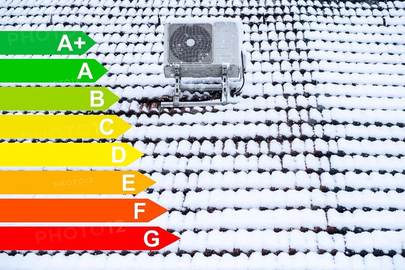 Air conditioning system on a snow-covered roof, graphic with energy efficiency classes for buildings according to the GEG, Essen, Germany, energy efficiency, Europe