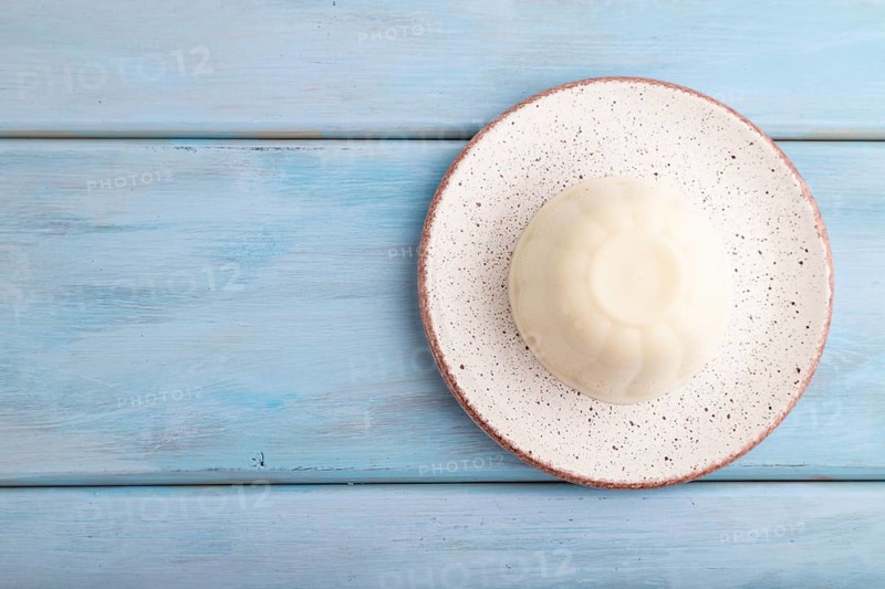 White milk jelly on blue wooden background. top view, flat lay, copy space