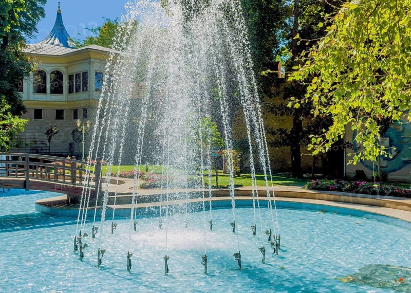 Water fountain in shallow pool in public park on sunny afternoon in Istanbul, Tuerkiye