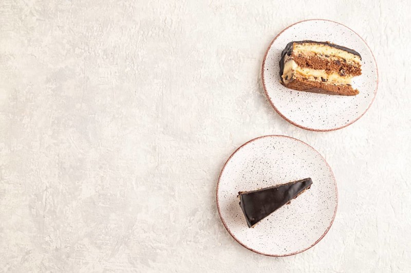 Chocolate biscuit cake with caramel cream and walnuts, on gray concrete background. top view, flat lay, copy space