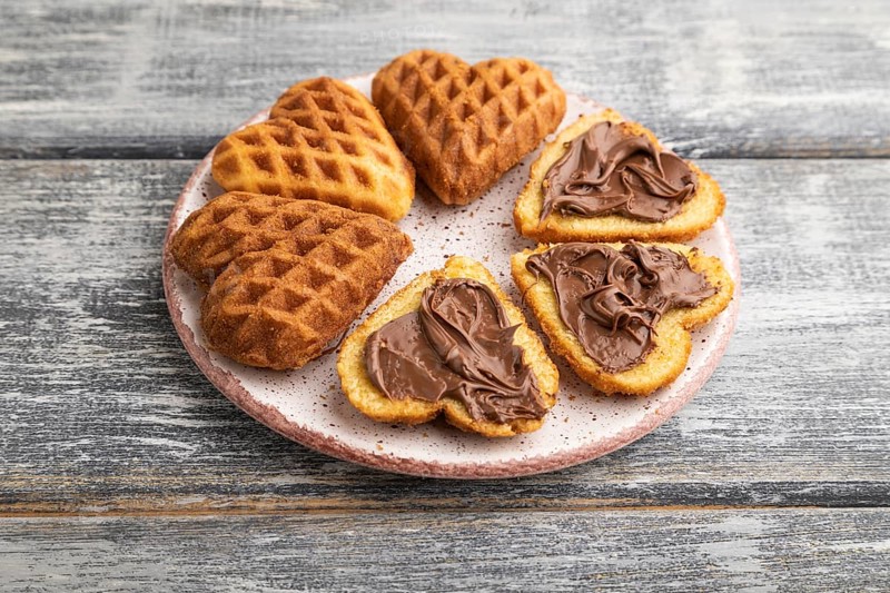 Homemade waffle with chocolate butter on a gray wooden background. side view, close up
