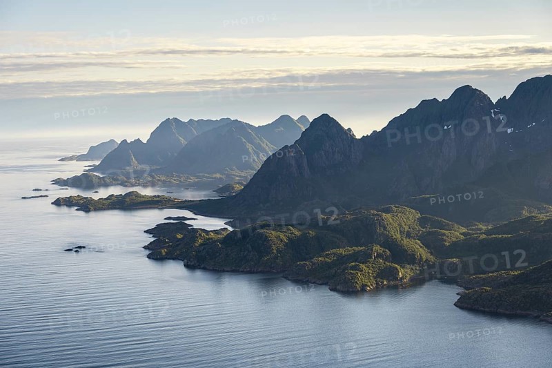 View of the coast in Ulvagsundet fjord and mountains in the evening light, Hurtigruten cruise ship in the fjord, view from the summit of Dronningsvarden or Stortinden, Vesteralen, Norway, Europe