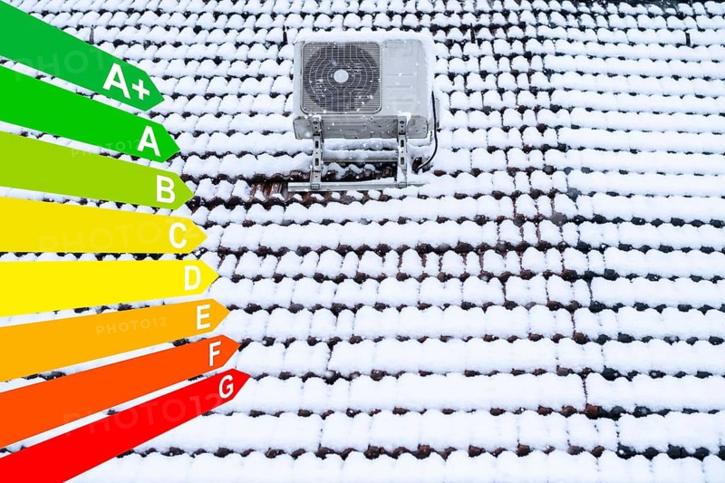 Air conditioning system on a snow-covered roof, graphic with energy efficiency classes for buildings according to the GEG, Essen, Germany, energy efficiency, Europe