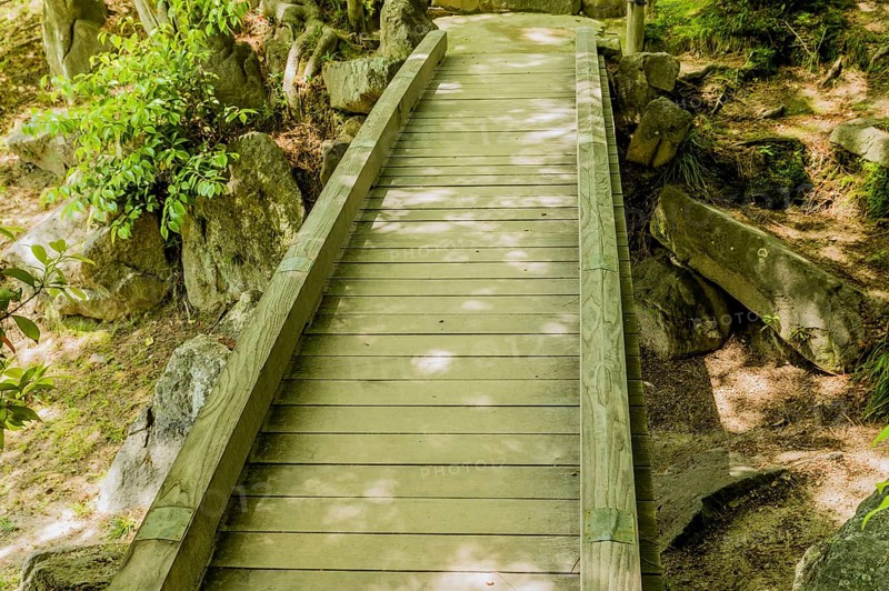Shaded wooden footbridge in Japanese Shukkeien Gardens in Hiroshima, Japan, Asia