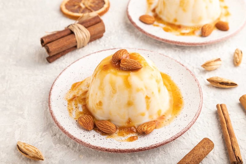 White milk jelly with caramel sauce on gray concrete background. side view, close up