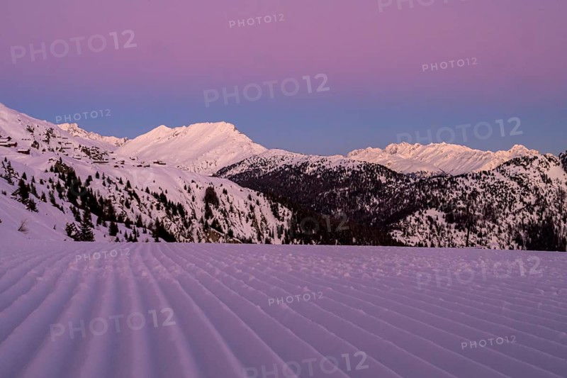 Snow-covered mountains at dusk with a purple sky and a freshly groomed ski slope in the foreground, Belalp, Naters, Brig, Canton Valais, Switzerland, Europe