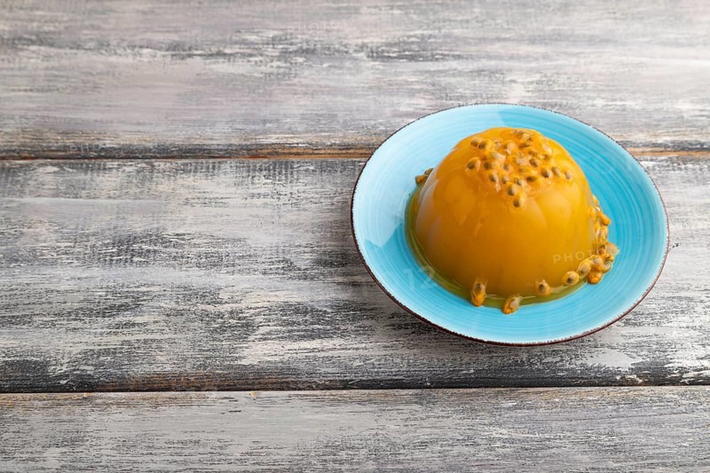 Mango and passion fruit jelly on gray wooden background. side view, copy space