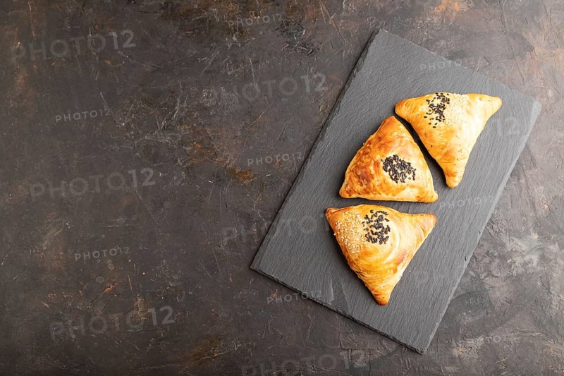 Homemade asian pastry samosa on black concrete background. top view, flat lay, copy space