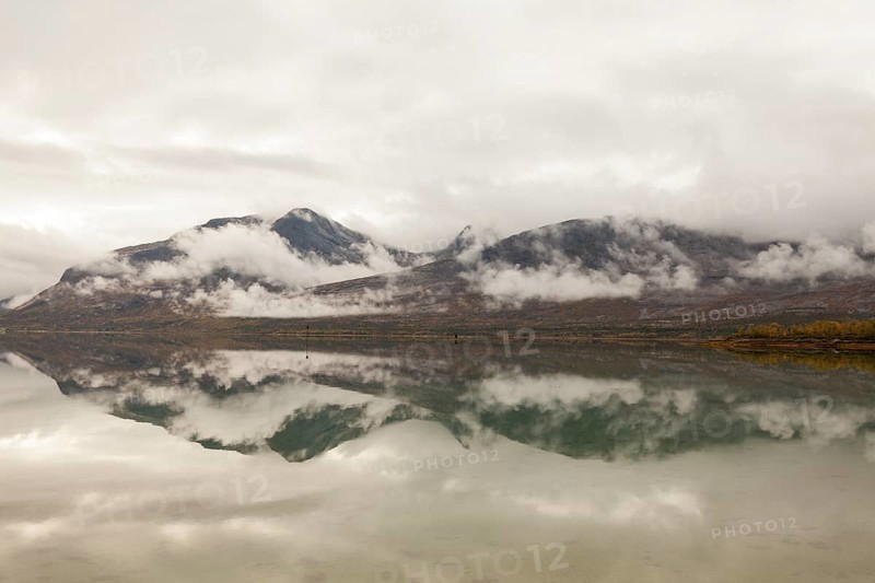 Beautiful foggy mood with lake reflection in the fjord in northern Norway Kjerringstraumen Bru Efjord