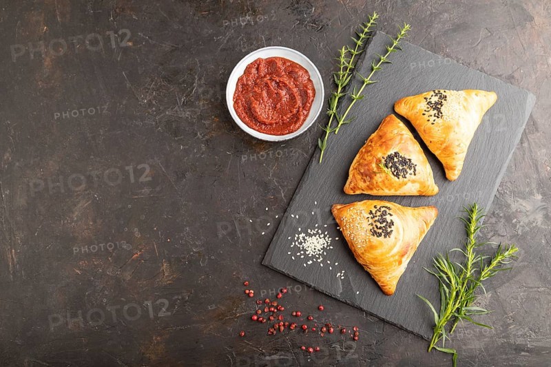 Homemade asian pastry samosa on black concrete background. top view, flat lay, copy space