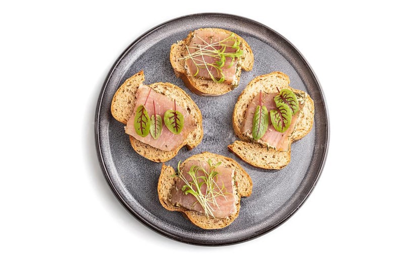 Bread sandwiches with jerky salted meat, sorrel and cilantro microgreen isolated on white background. top view, flat lay, close up